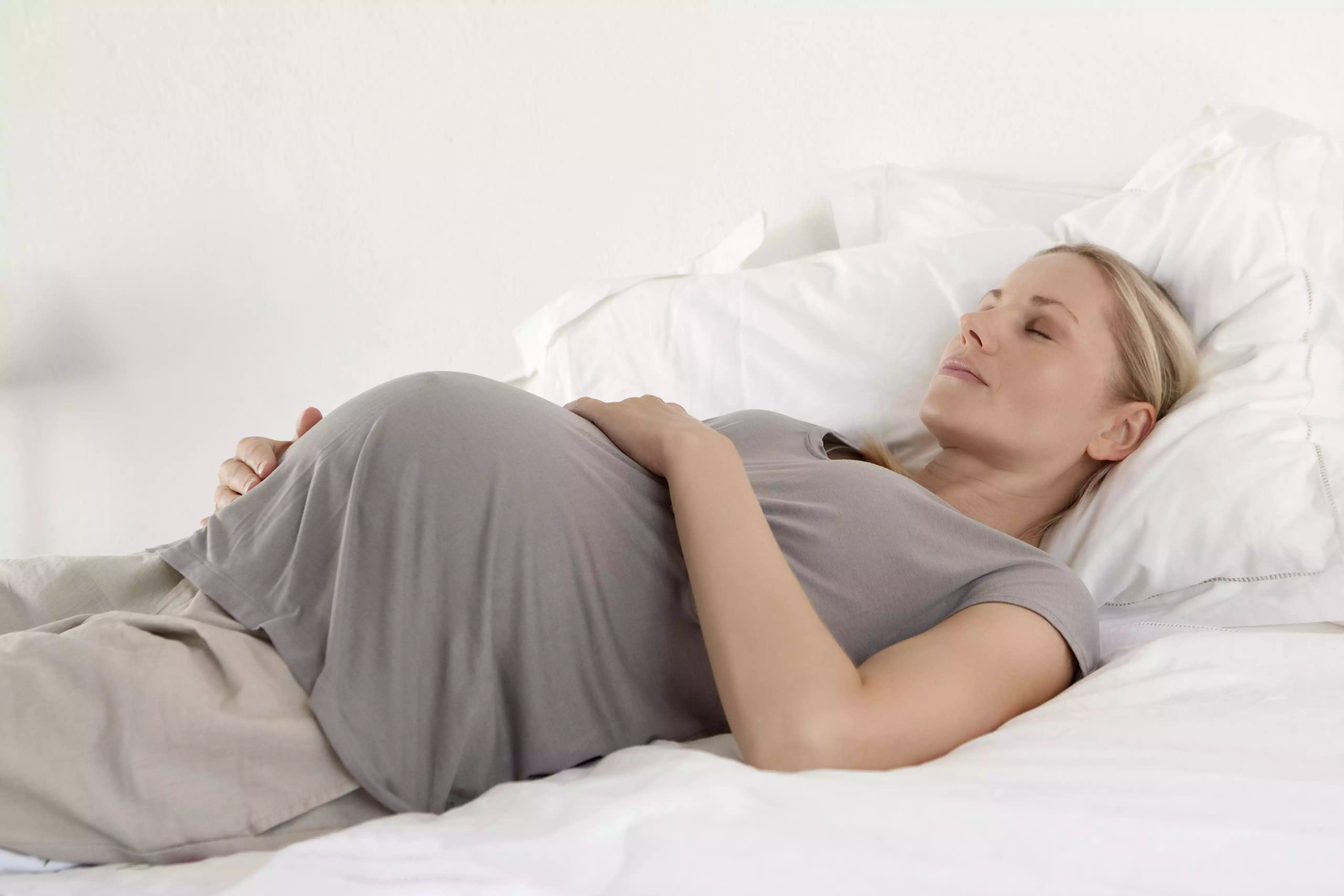 Pregnant woman asleep on her bed