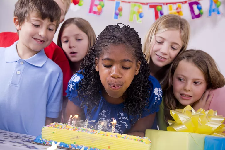Çocuklar bir Doğum günü pastası mumlar üfleme